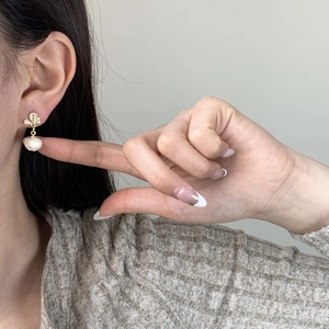 Elegante goldene Schmetterlingsohrringe mit Barockperlen-Anhänger am Model gezeigt