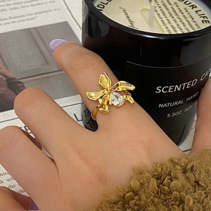 Gold orchid flower ring with teardrop zircon on a 45-degree angle lifestyle setting