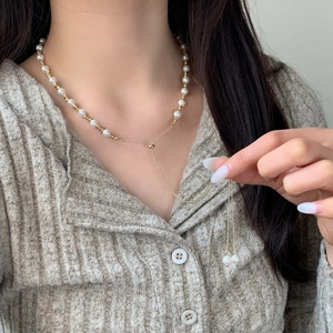 Adjustable Y-shaped freshwater pearl necklace with gold sliding clasp on a model
