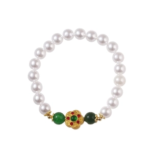 Ethnic handmade pearl bracelet with gold flower charm and green beaded accents
