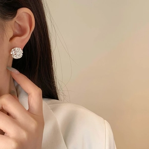 Vintage silver hollow woven geometric earrings with a polished metallic finish on a model