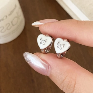 Élégantes boucles d'oreilles cœur en argent avec émail blanc et détail nœud à la main