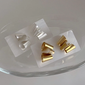 Macro detail of irregular matte twisted geometric earrings in gold and silver plating