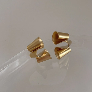 Detail of matte gold irregular twisted geometric earrings with minimalist streamlined design