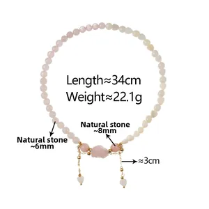 Macro detail of natural strawberry quartz bracelet with pink stone heart charm and chain