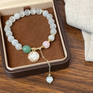 Handmade beaded bracelet with cat eye stones and mother-of-pearl smiley face pendant