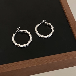 Detailed view of silver hoop earrings featuring irregular geometric crushed silver beads