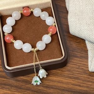 Bracelet élégant en perles blanches et rouges avec pendentif fleur dans un écrin à bijoux