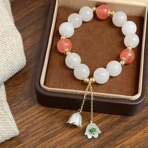 Bracelet en perles de pierre naturelle avec pendentifs muguet dans un écrin à bijoux