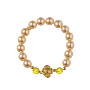 Bracelet en perles dorées avec perles en verre jaunes et breloque fleur sur fond blanc