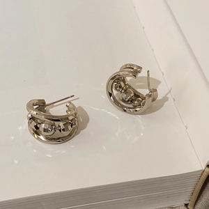 Détail macro de boucles d'oreilles créoles dorées avec perles métalliques facettées
