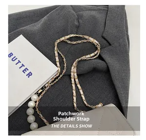 Detail of elegant shoulder strap with oversized white pearls and gold metal chain