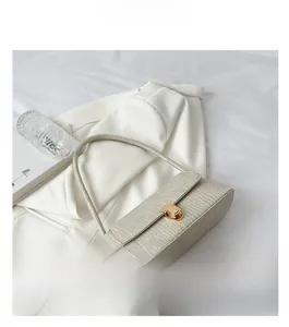 Détail du sac à bandoulière beige motif crocodile avec fermoir en métal doré
