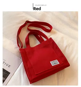 Top view of red canvas tote bag with adjustable shoulder strap and woven logo detail