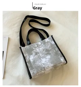 Detail of grey tie-dye canvas tote bag with black leather trim and shoulder strap