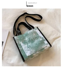 Detailed top view of green tie-dye canvas tote bag with black straps and outer pocket
