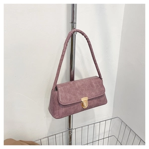 Détail du sac sous le bras lilas montrant la texture crocodile et la boucle dorée