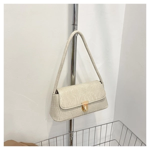 Détail du sac baguette blanc crème avec motif crocodile et boucle en métal doré