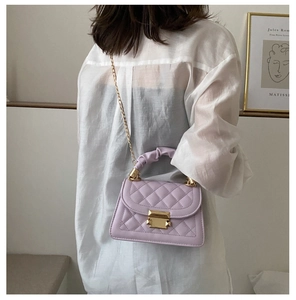 Detail of lavender quilted crossbody bag featuring chain strap and textured handle