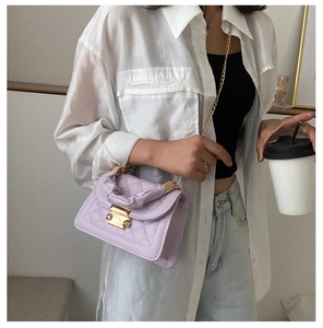 Detail of lavender quilted crossbody bag with gold twist lock and ruffled handle