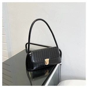 Gros plan du sac porté épaule noir à motif crocodile avec une boucle en métal doré