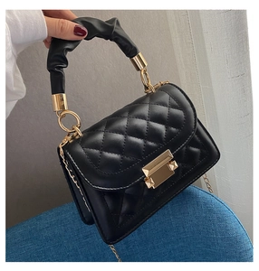 Handheld view of black quilted leather bag with cloud handle and gold chain strap
