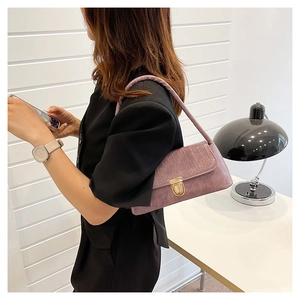 Sac baguette lavande avec texture crocodile et fermoir doré porté par un modèle