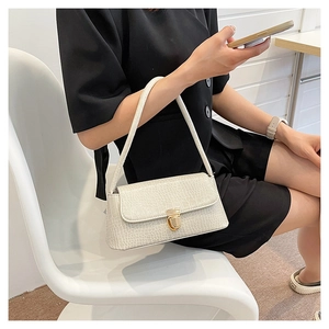 Détail d'un sac à épaule blanc effet crocodile avec boucle dorée vintage