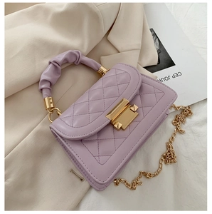 Close-up of lilac quilted crossbody bag with gold lock and ruched cloud handle
