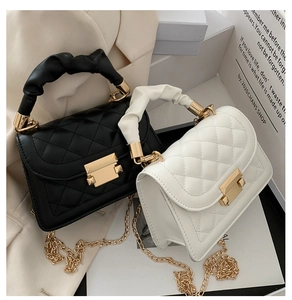 Detailed view of quilted leather texture and golden metal chain strap on a crossbody bag