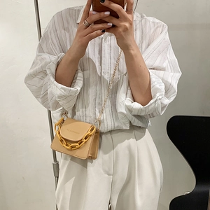 Beige mini PU leather crossbody bag with bold yellow chain and metal shoulder strap