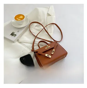 Litchi pattern brown mini trapezoid bag with gold hardware lock and crossbody strap
