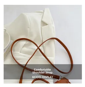Detail of a brown cross-grain leather strap on a stylish mini top handle handbag