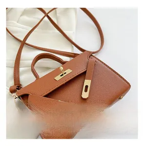 Detail view of brown Epsom leather mini handbag with gold hardware and top handle