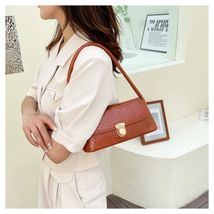 Gros plan du sac porté épaule marron à texture crocodile avec boucle en métal doré