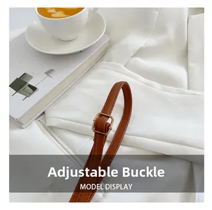 Detail of brown lychee texture leather strap with adjustable golden metal buckle