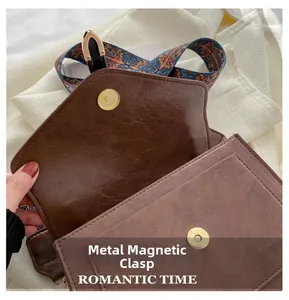 Detailed close-up of a secure magnetic buckle on a vintage oil-wax leather shoulder bag