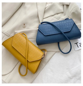 Detailansicht der gelben und blauen Kroko-Umschlagtaschen mit goldenen Schnallen
