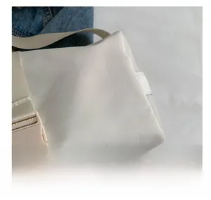 Detail shot of white nylon bag featuring adjustable side buckle and durable strap texture