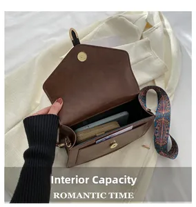 Macro detail of the interior compartment and pocket of this brown crossbody bag