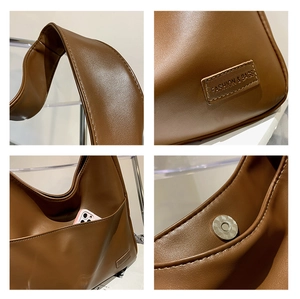 Detail showing the magnetic snap button, side pocket, and faux leather texture of the bag
