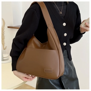 Close-up of brown vintage tote bag with wide strap and fashion leather label detail