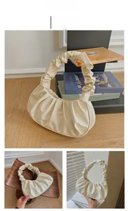 Detail view of beige ruched dumpling bag with smooth PU texture and pleated handle