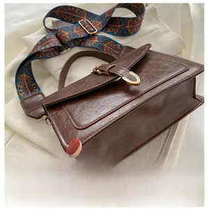 Close-up of the reinforced bottom structure on a vintage brown leather crossbody bag