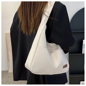 Detail of off-white leather tote bag with side pocket and vintage brown leather tag