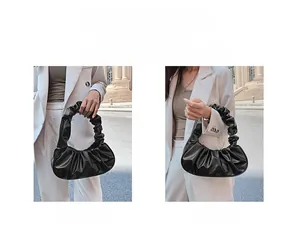 Model showcasing multiple ways to carry the shiny black pleated cloud handbag on city streets