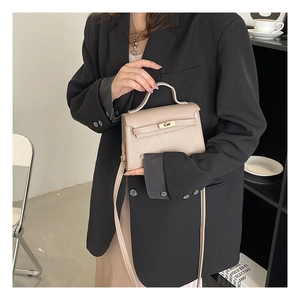 Mini beige textured leather Kelly style bag with metal clasp and thin shoulder strap