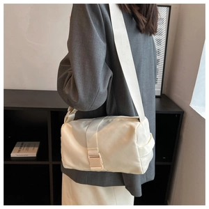 Detailed back view of off-white nylon crossbody bag with adjustable wide strap on model