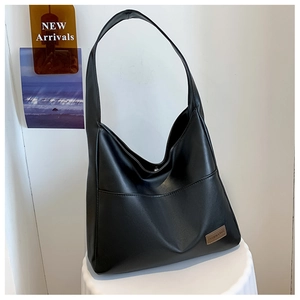 Detail of black leather shoulder bag with FASHION & BAGS tag on a white pedestal