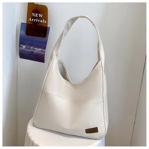 Detail view of a cream white hobo shoulder bag with matte leather finish on a display